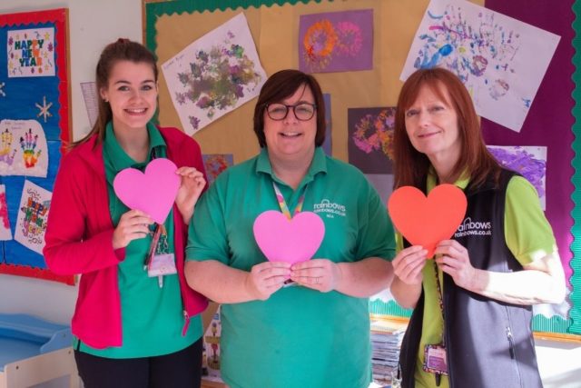 Three nurses holding hearts