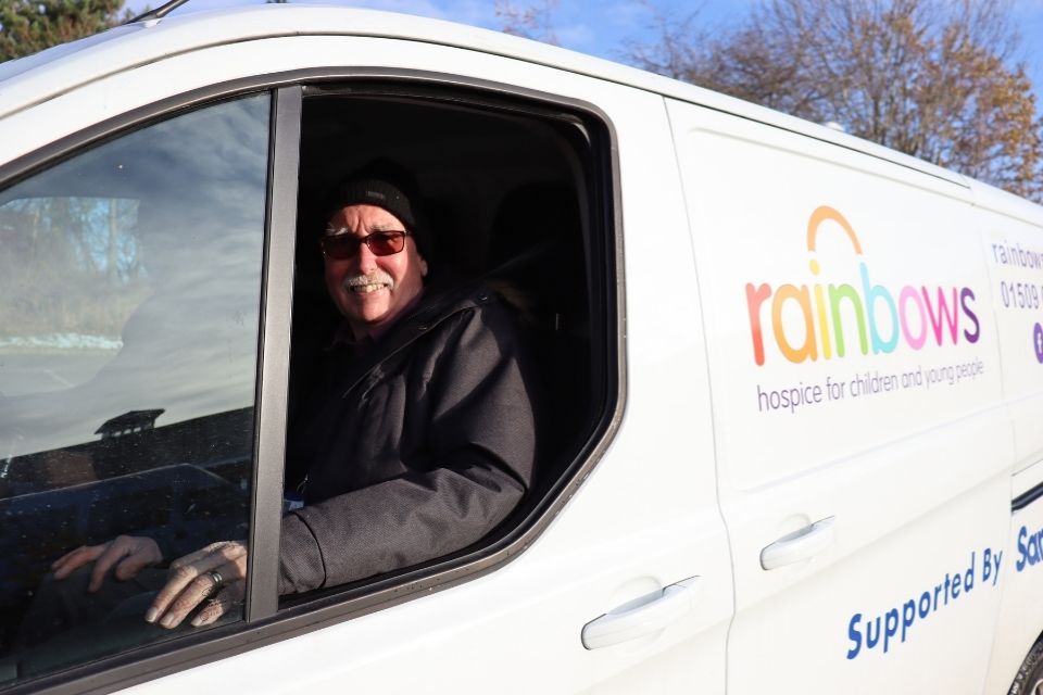Van driver smiling in a Rainbows van