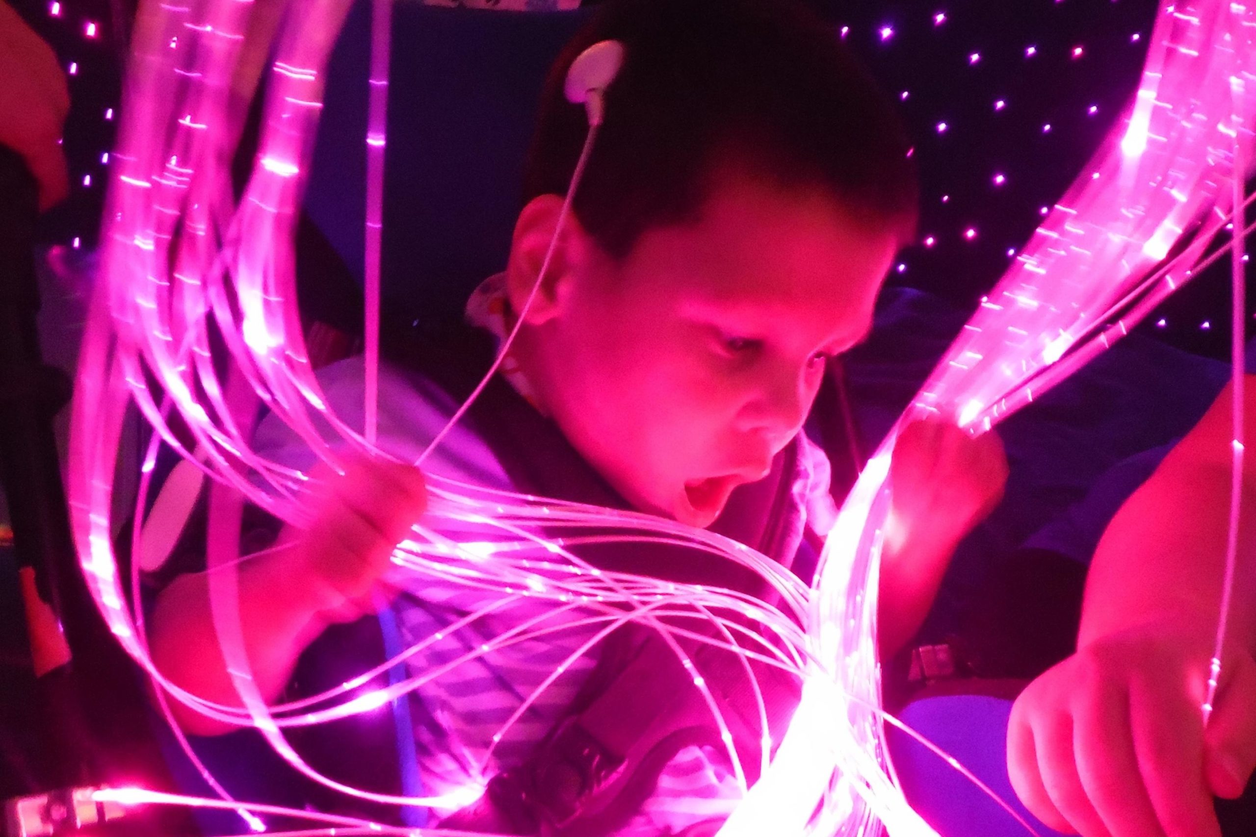 A young boy with purple lights around him