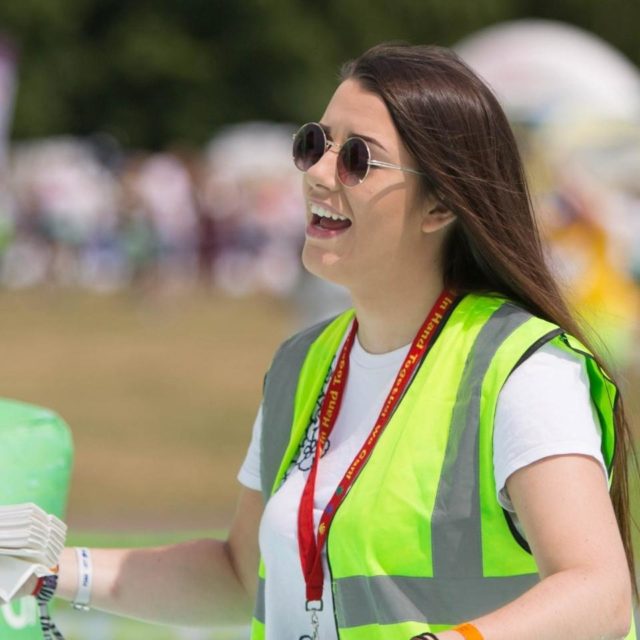 A smiling event volunteer for Rainbows