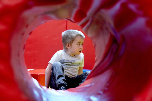 A young boy sat in soft play