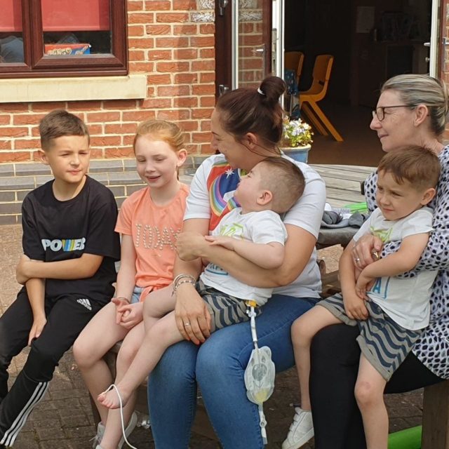 A family sat outside in the sun