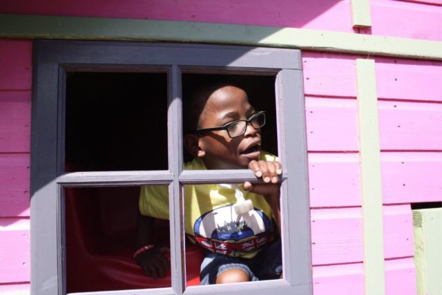 A young boy looking at of a window