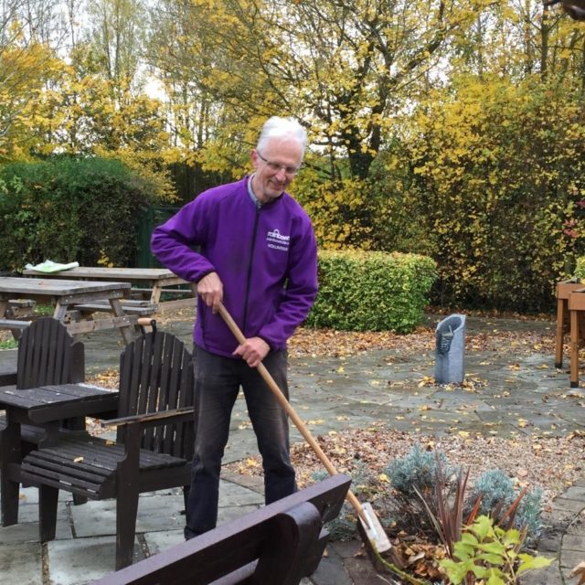 An elderly gentleman sweeping in the garden