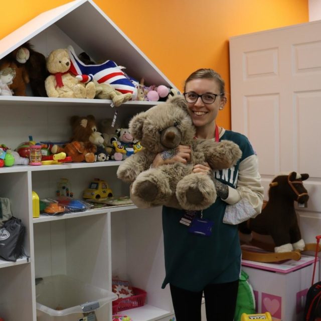 A smiling volunteer in a Rainbows shop