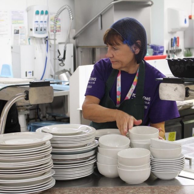 A lady volunteering in the kitchens at Rainbows