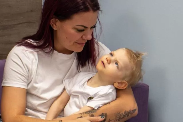 A mum holding her young daughter and smiling