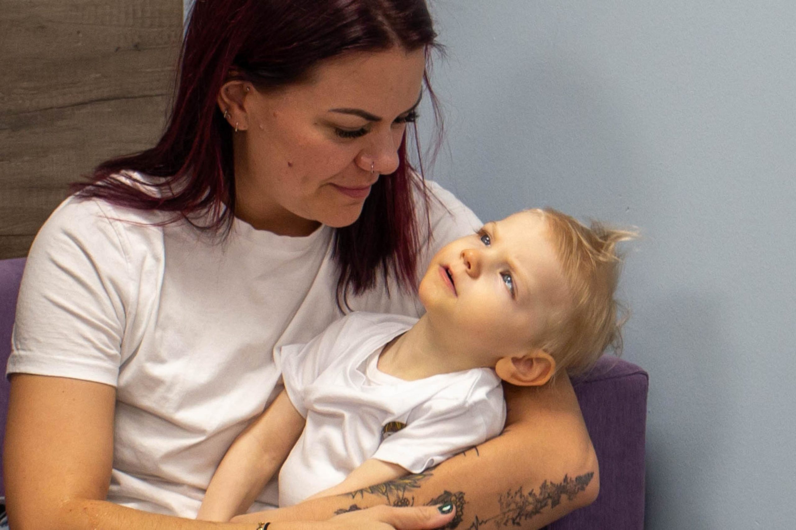 A mum holding her young daughter and smiling